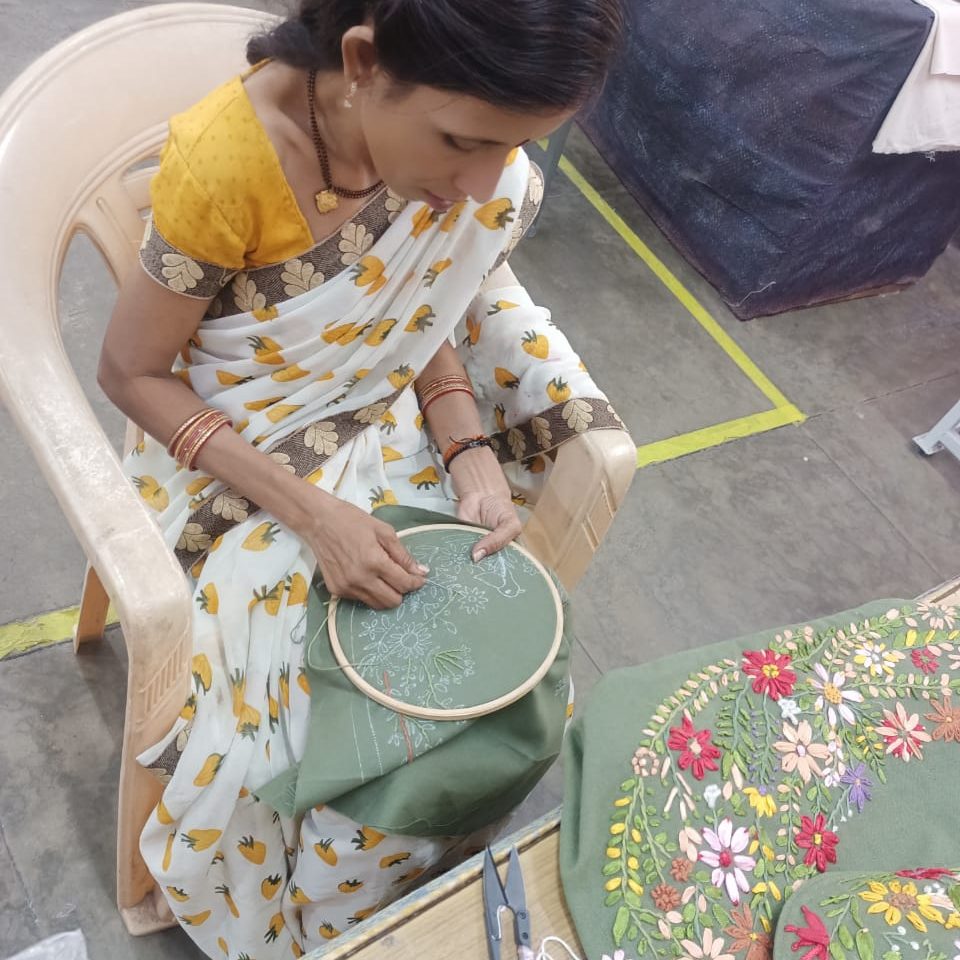 Stickerin bei SSMI in Delhi fertigt eine Sundapath-Tasche
